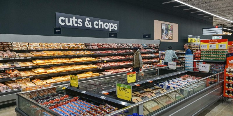 Busy retail grocery store aisle featuring a variety of fresh cuts and chops, showcasing the diverse selection in the meat and butcher section